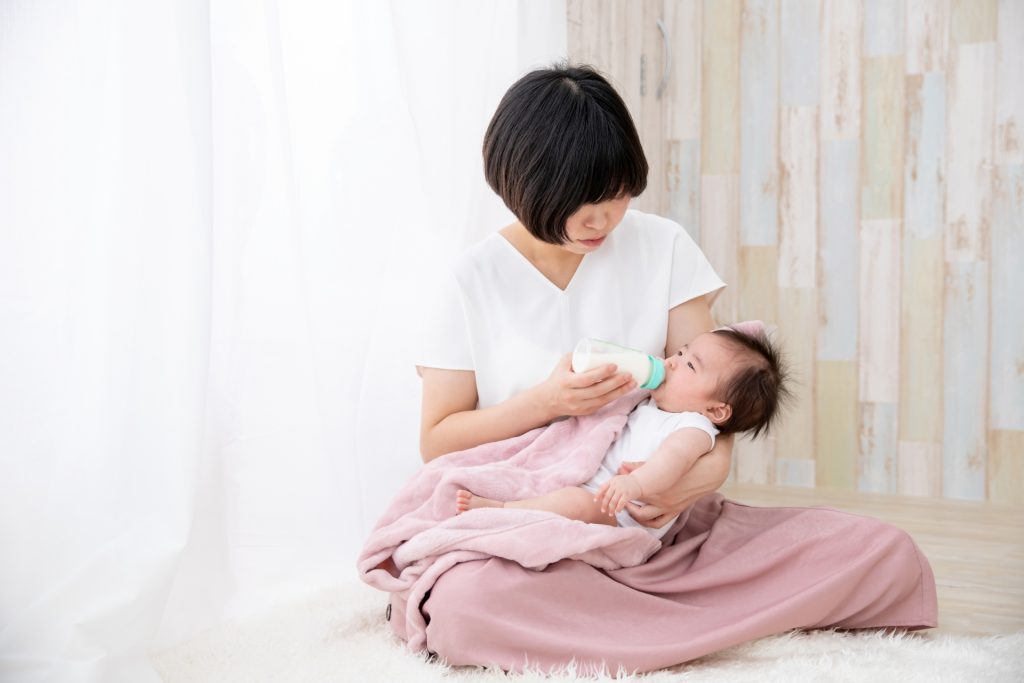 ミルクを飲ませている女性と赤ちゃん